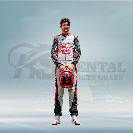 Person in a racing suit holding a helmet with a blurred background featuring a brand logo.